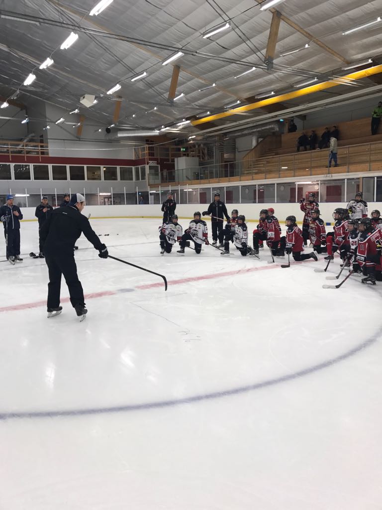 Eetu Qvist teaching young ice hockey players proper skating technique.